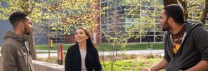 Three Rowan University computer science majors chat together outside on campus.