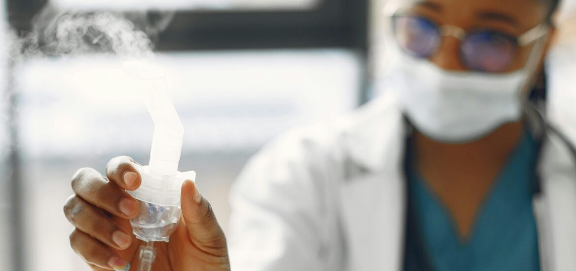 A respiratory therapist holds a nebulizer.
