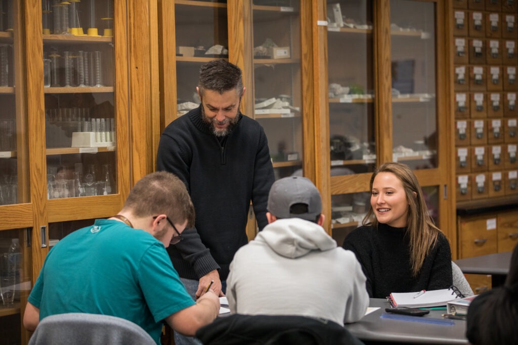 Professor mentoring students in a collaborative classroom, modeling teacher leadership in action