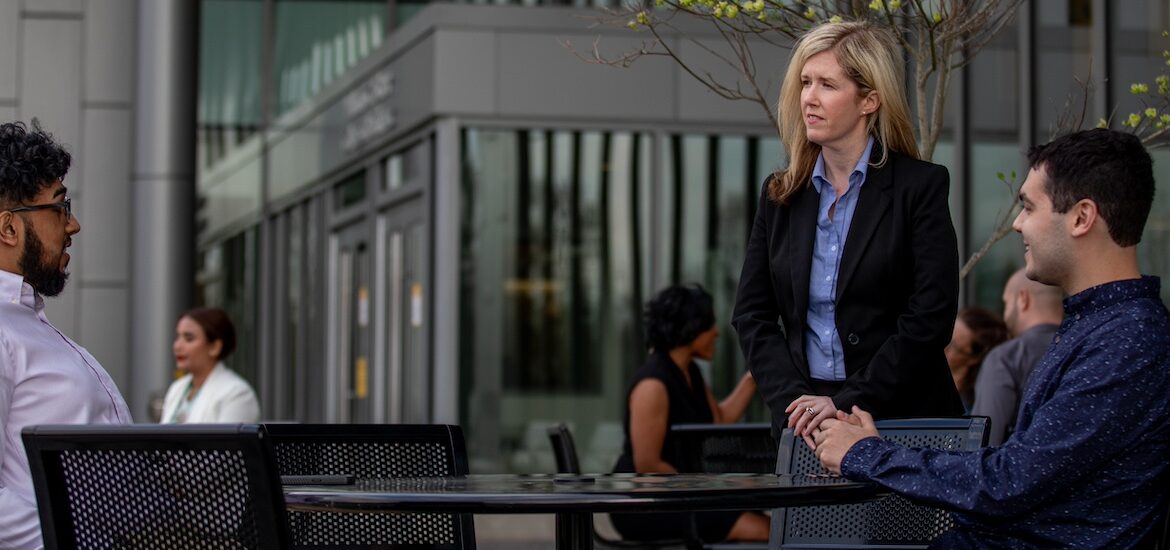 Rowan master's in cybersecurity experts sit outside an office.