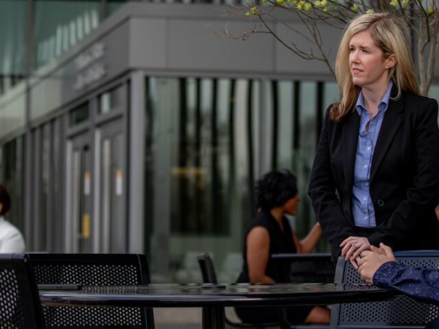 Rowan master's in cybersecurity experts sit outside an office.