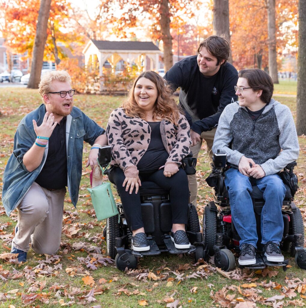 Four Rowan University friends socialize together outdoors, chatting.