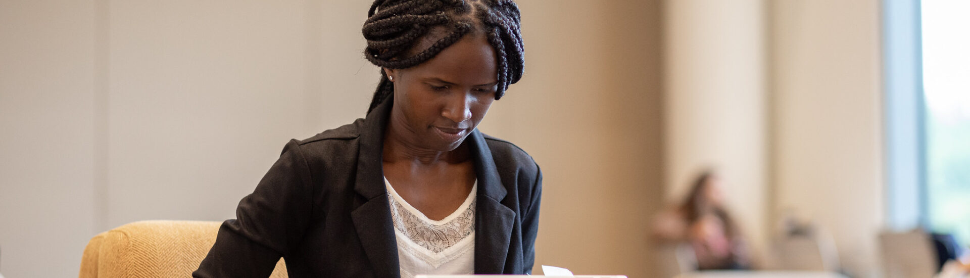 Professional woman working on a laptop in a quiet study area, representing the flexibility of an online MBA program.