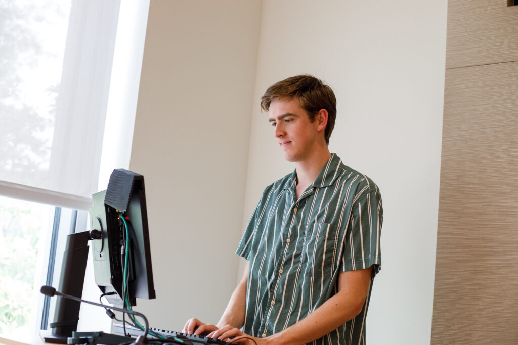 Student at standing desk engaging in coursework for masters in cybersecurity online