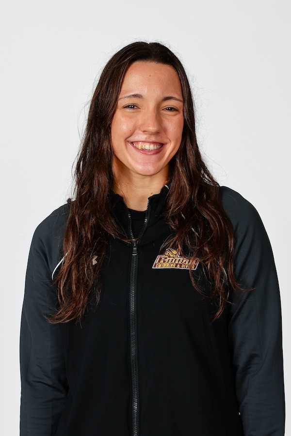 Kaitlyn smiles at the camera for a portrait, wearing a Rowan Swimming zip up.
