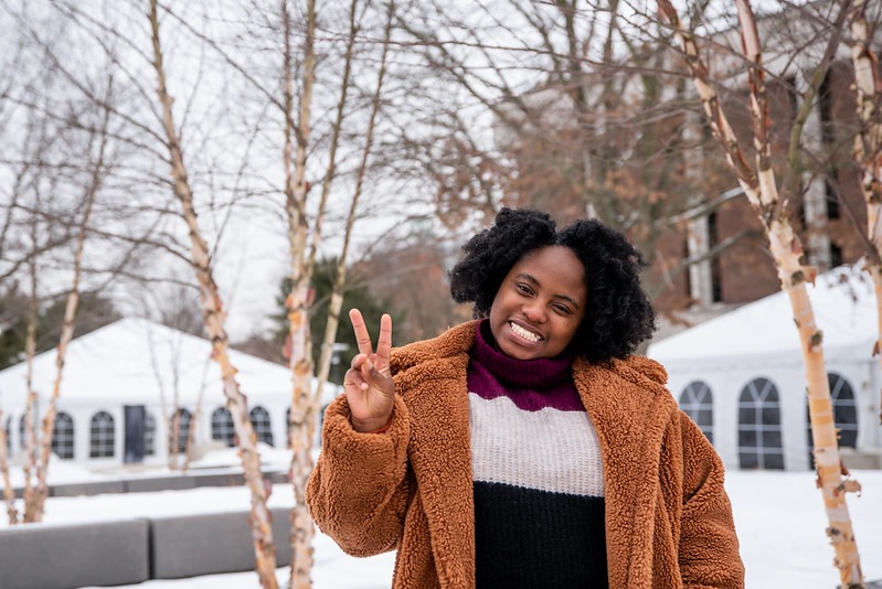 A happy and grateful student at Rowan University flashes a peace sign outside in the snow.