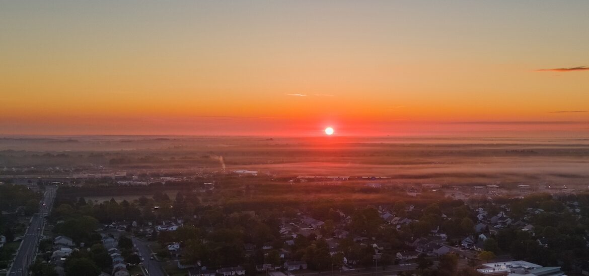 A drone photo overlooking the entirety of Rowan University's campus during a sunrise while it's still mostly dark.