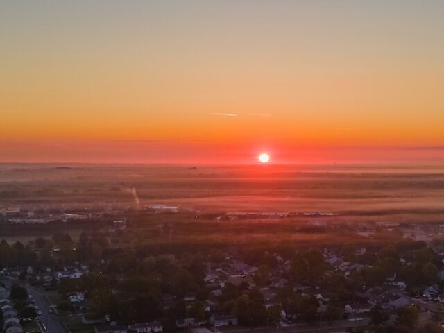 A drone photo overlooking the entirety of Rowan University's campus during a sunrise while it's still mostly dark.
