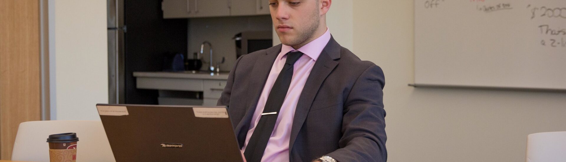 Professional student researching MBA online programs at work.