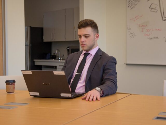 Professional student researching MBA online programs at work