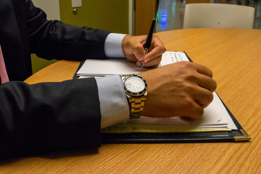 Online professional MBA student planning courses and writing notes