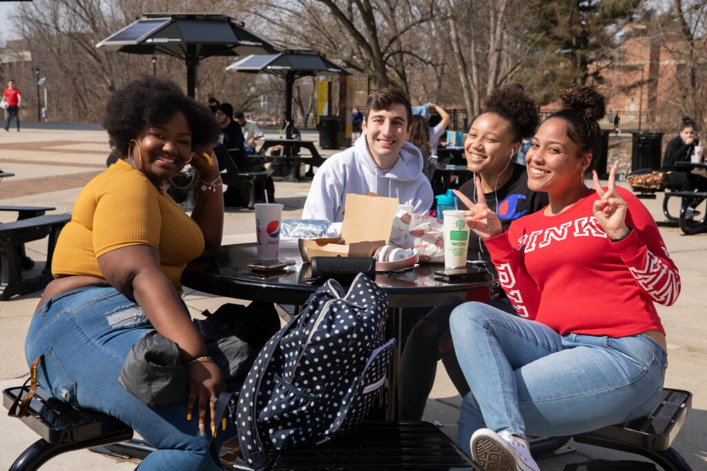 Students eating lunch outdoors and comparing food options—showing how everyday decision-making reflects skills taught in an online business administration degree program or a bachelor's degree in business