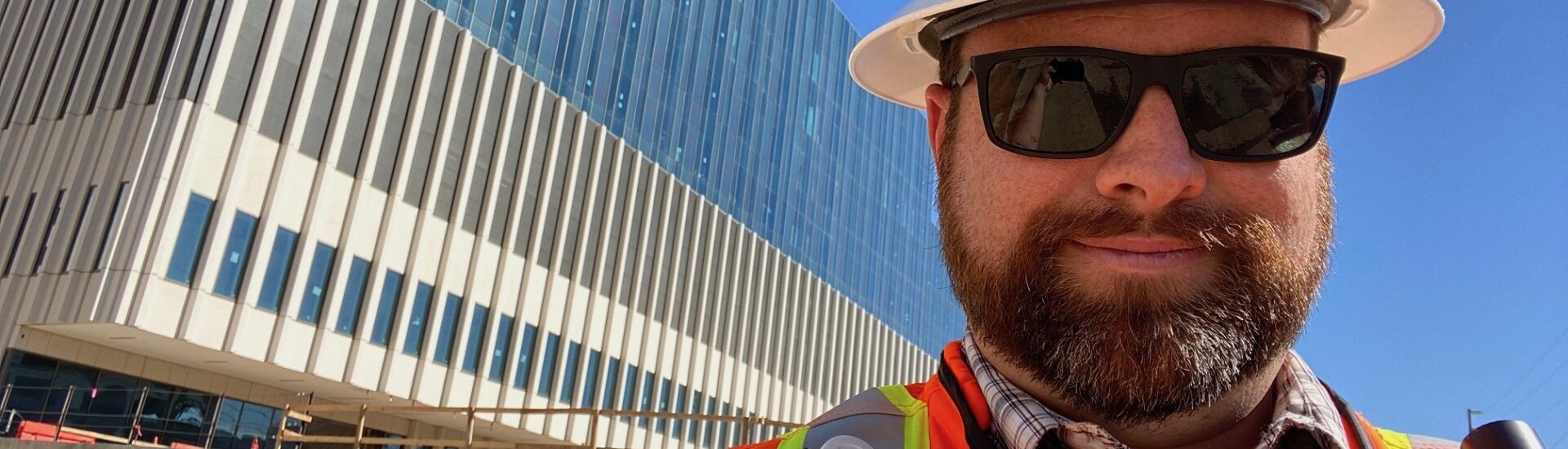 Construction professional wearing hard hat and safety vest at a job site representing bachelors degree in construction and construction management BS career opportunities.
