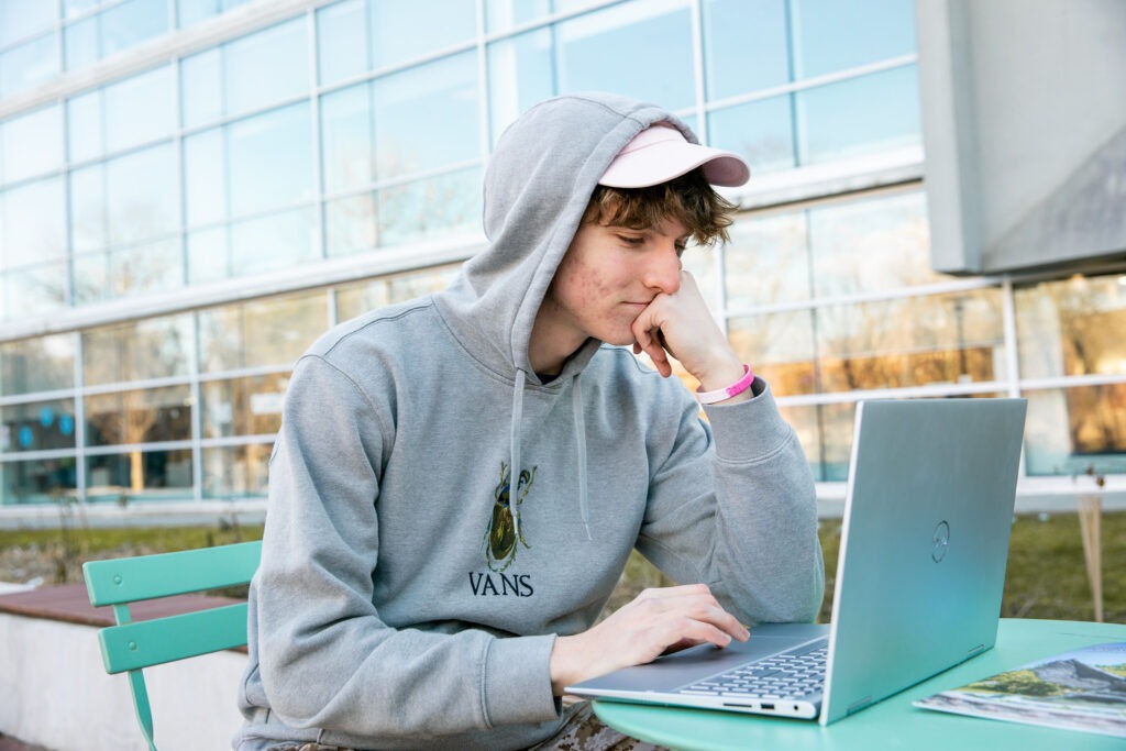 Student studies independently outside as part of a flexible data analyst online program