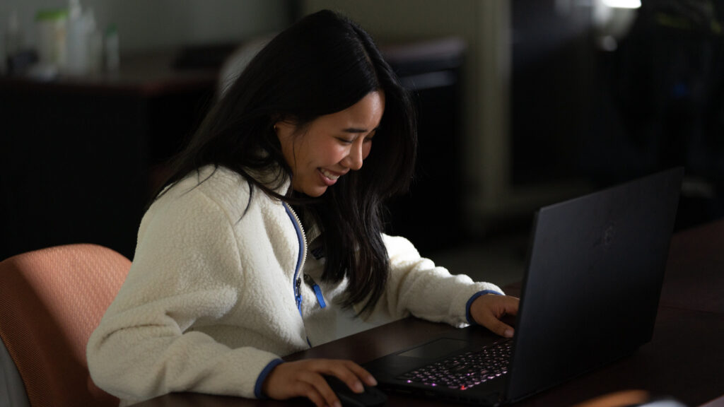 Student smiling while learning in a business analytics degree online course