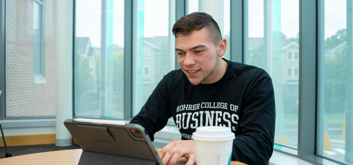 Student works on a tablet while studying in an online data analytics program