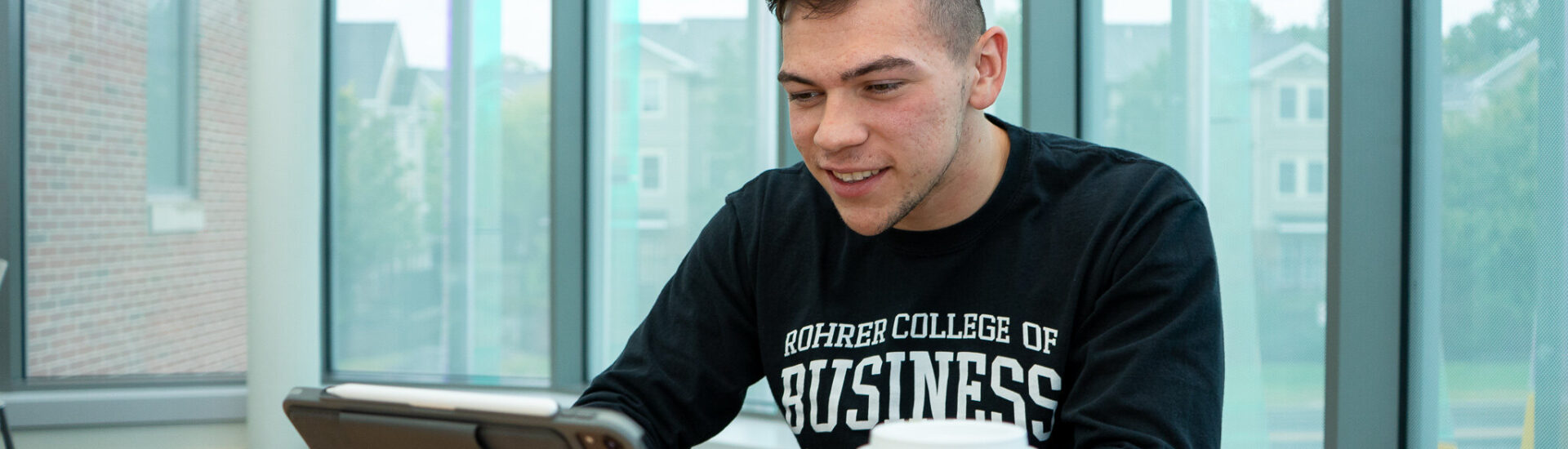 Student works on a tablet while studying in an online data analytics program.