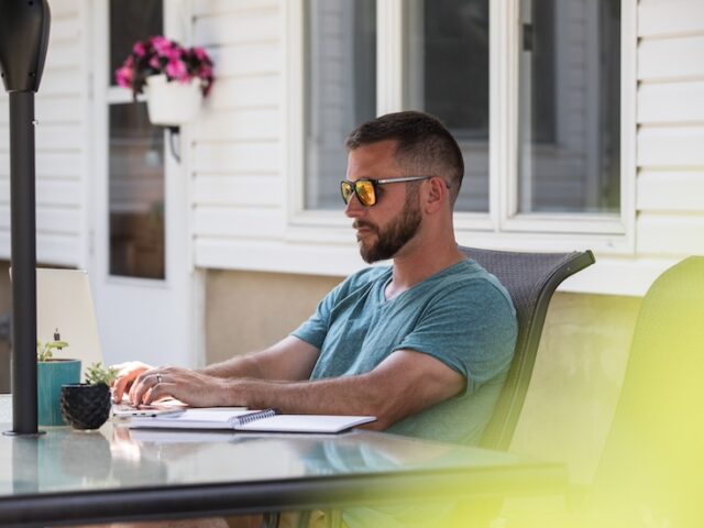 A Rowan Bachelor of Science of Nursing online BSN student studies in his backyard.
