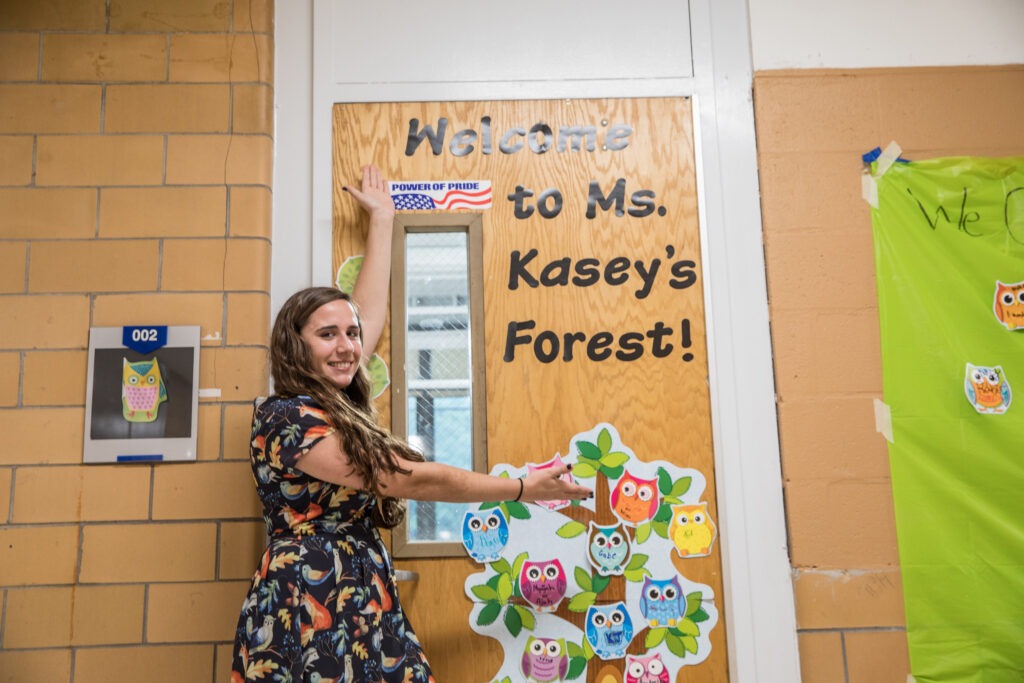 Teacher welcoming students to a creative learning space—perfect for those pursuing masters programs for teachers