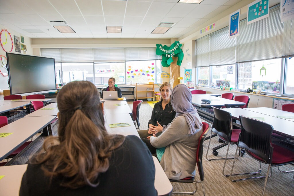Graduates of educational technology master's program collaborating in classroom environment