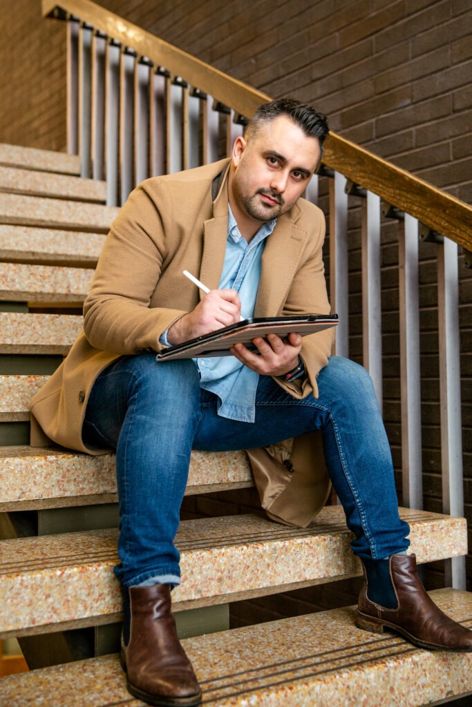 Student studying for a career in educational technology while sitting on steps with iPad