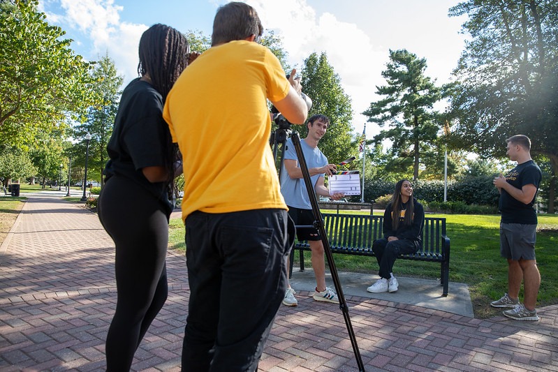 Five radio TV film students at Rowan work together outside to shoot a project for class.