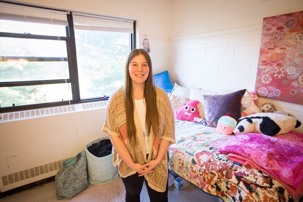 Mimosa resident assistant stands in her bedroom at Rowan University