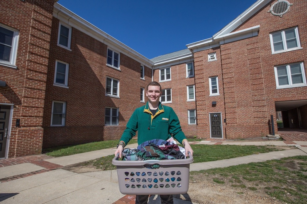 Chesnut Hall resident carries a laundry basket at Rowan University.