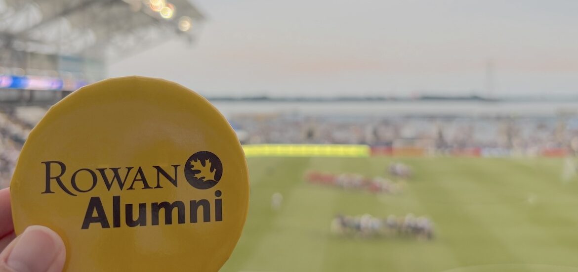 A Rowan University Alumni button in front of a Philadelphia Union game.