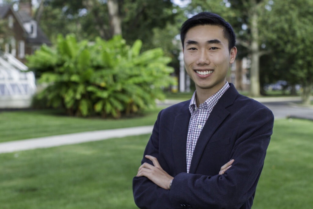 Young professional in a blazer smiling outdoors, representing career opportunities with an online MBA degree.