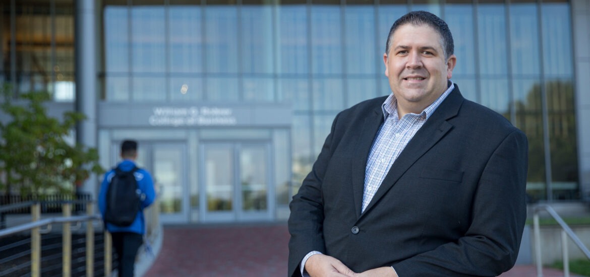 Rowan University business professional in front of the Rohrer College of Business, representing accredited online MBA programs.