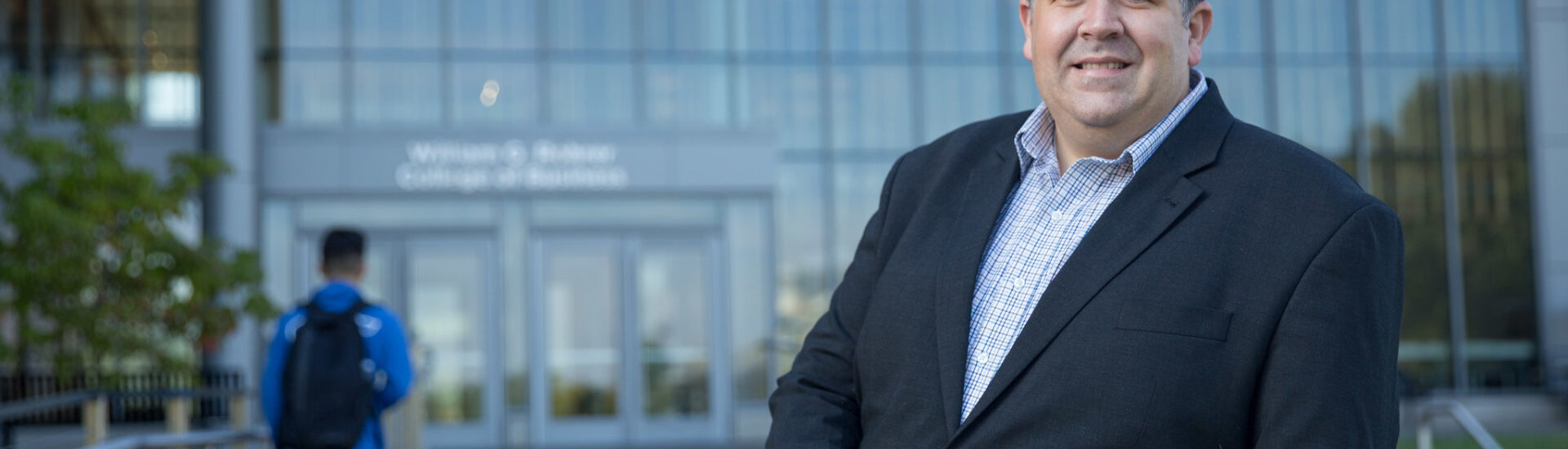 Rowan University business professional in front of the Rohrer College of Business, representing accredited online MBA programs.