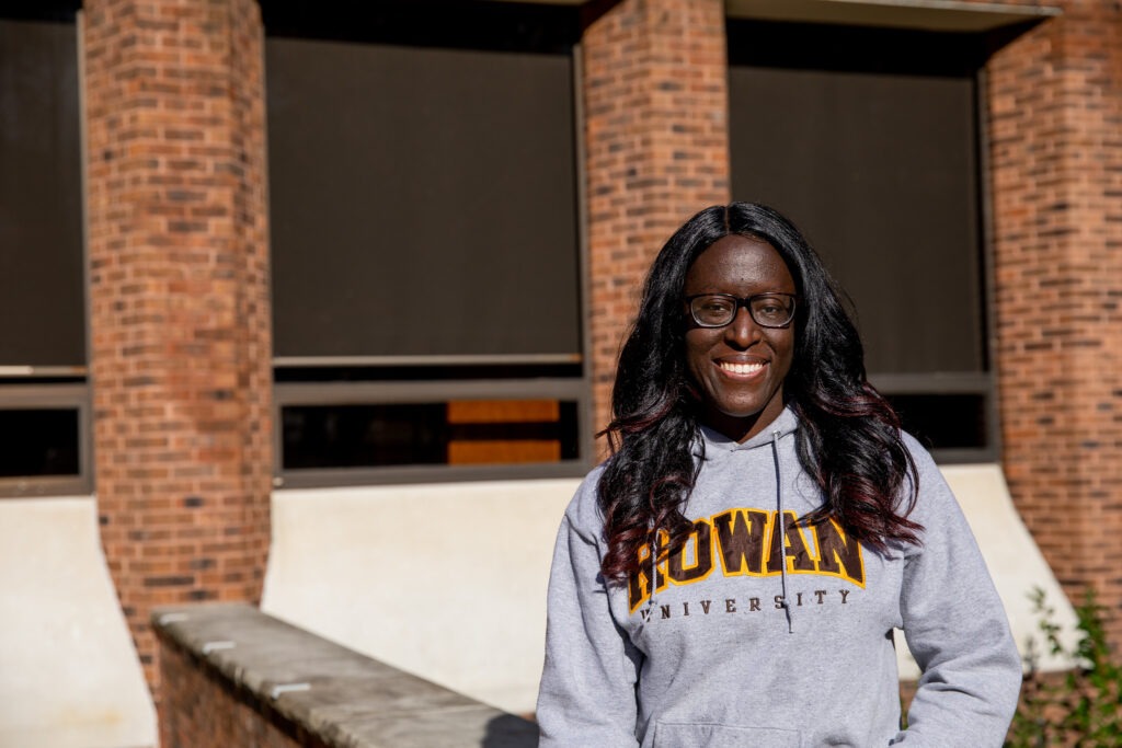 Rowan University student smiling in a Rowan sweatshirt, representing the reputation and flexibility of Rowan’s psychology bachelor’s degree online.