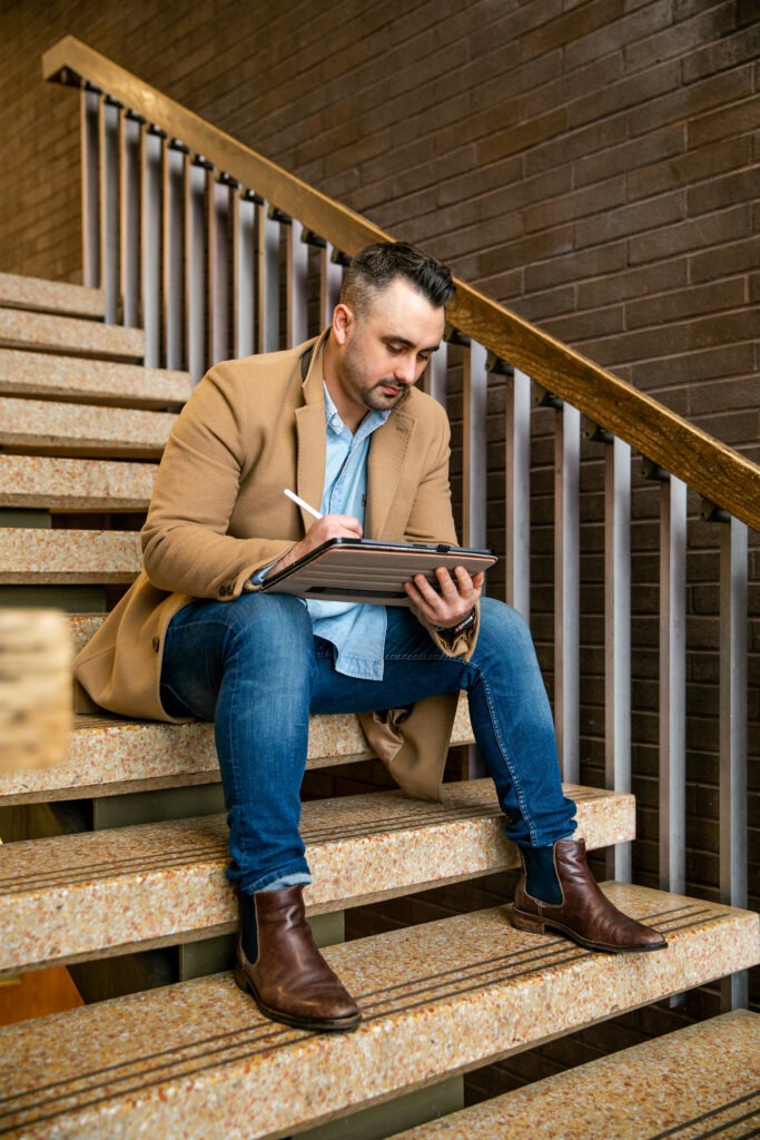 Male student studying on his tablet while balancing work and pursuing an online master’s in education.
