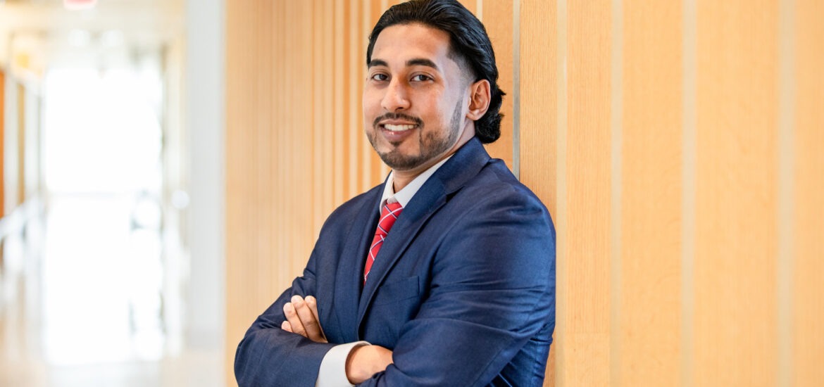 Business administration student in professional suit standing confidently, representing career opportunities with a bachelor’s in business administration.