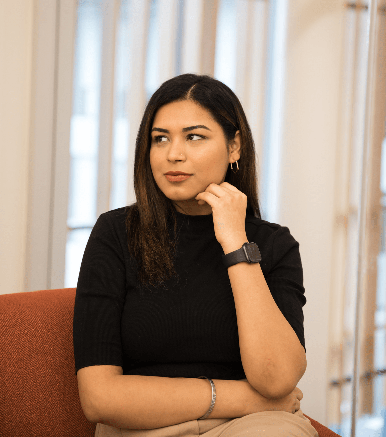 Professional woman in business attire thinking about career growth and the benefits of an online MBA degree.