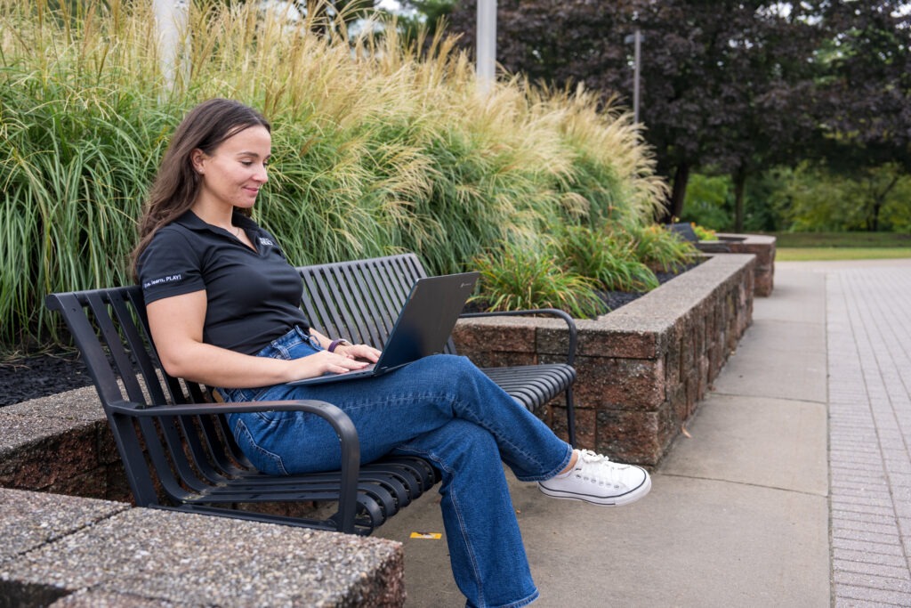 Rowan University graduate student studying outdoors for her online master’s in health and wellness.