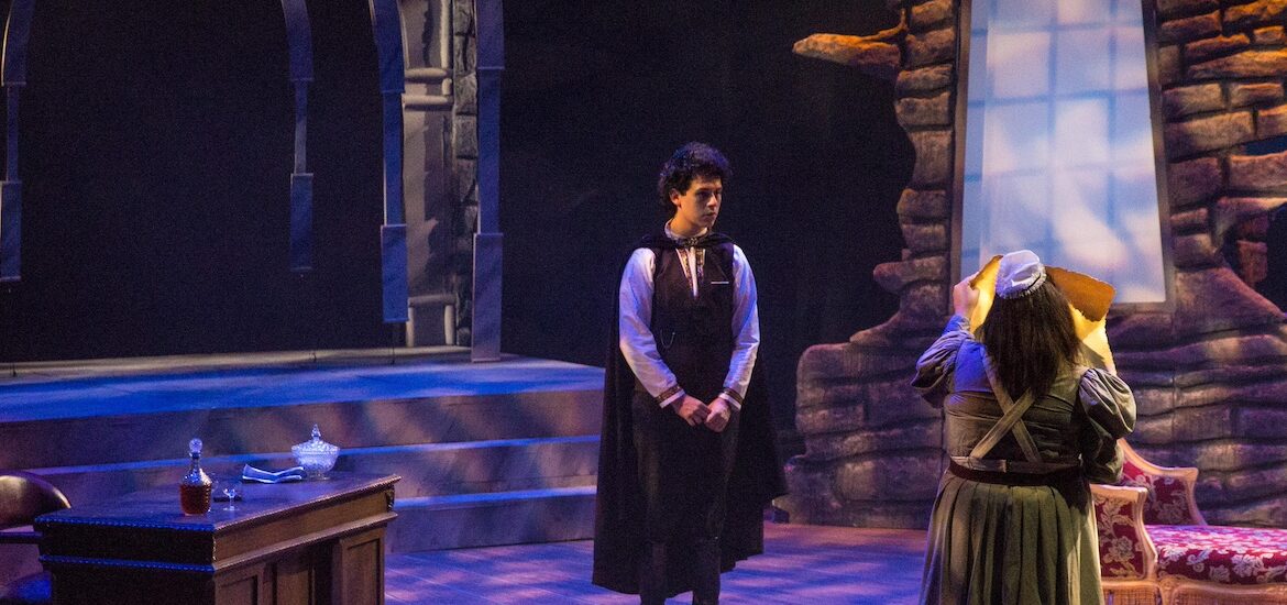 The dark and spooky set of Dracula at Rowan University, with two theatre majors on stage.