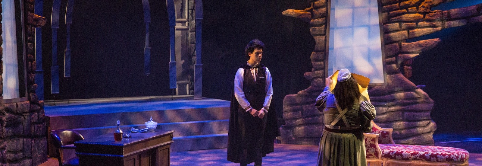 The dark and spooky set of Dracula at Rowan University, with two theatre majors on stage.