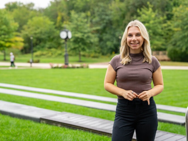 Online Ed.D. candidate at Rowan University smiling outside.