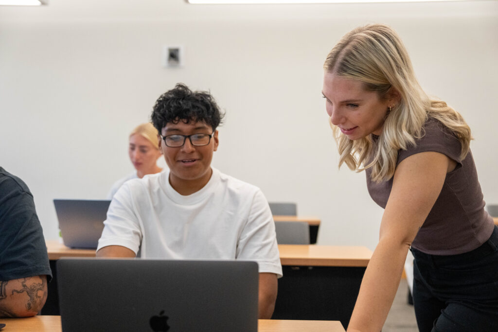 Online Ed.D. candidate, Samantha L., assisting a male student in one of the classes she teaches.