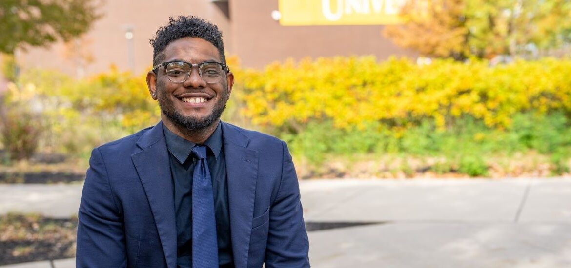 Shawn B. smiles outside Rowan University, representing connection and community in Rowan’s online Ed.D. in Educational Leadership program.