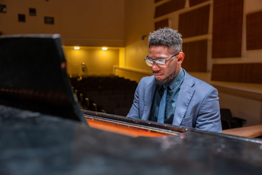 Shawn B. plays piano on stage, reflecting his passion for music, education, and leadership as a student in Rowan University’s online Ed.D. in Educational Leadership program.
