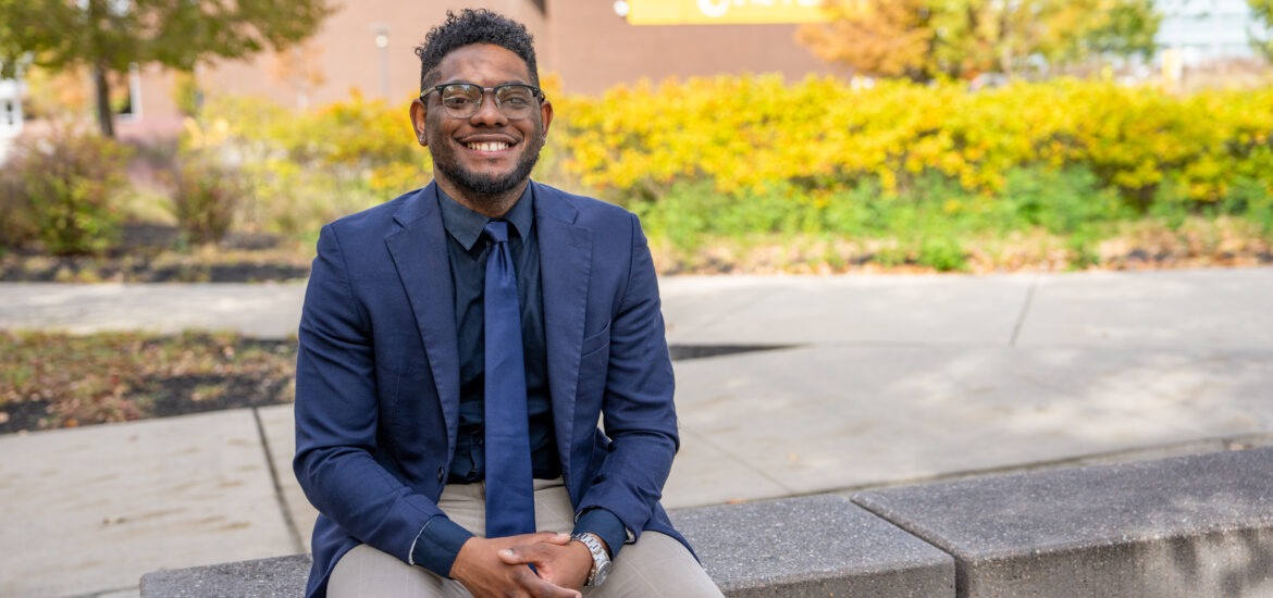Shawn B. smiles outside Rowan University, representing connection and community in Rowan’s online Ed.D. in Educational Leadership program.