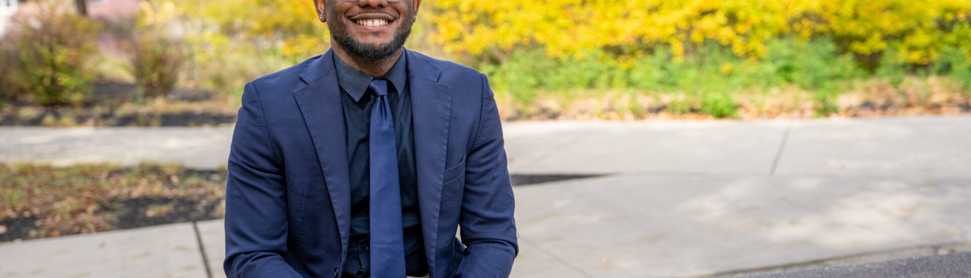 Shawn B. smiles outside Rowan University, representing connection and community in Rowan’s online Ed.D. in Educational Leadership program.