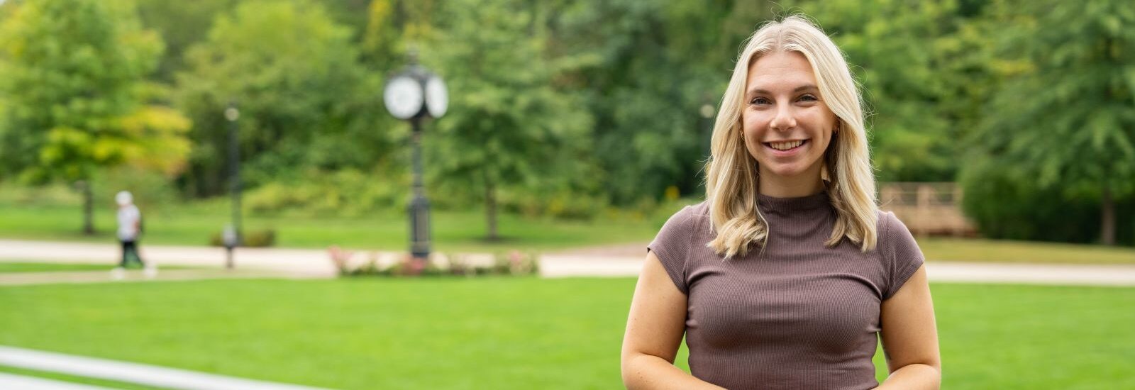 Online Ed.D. candidate at Rowan University smiling outside.