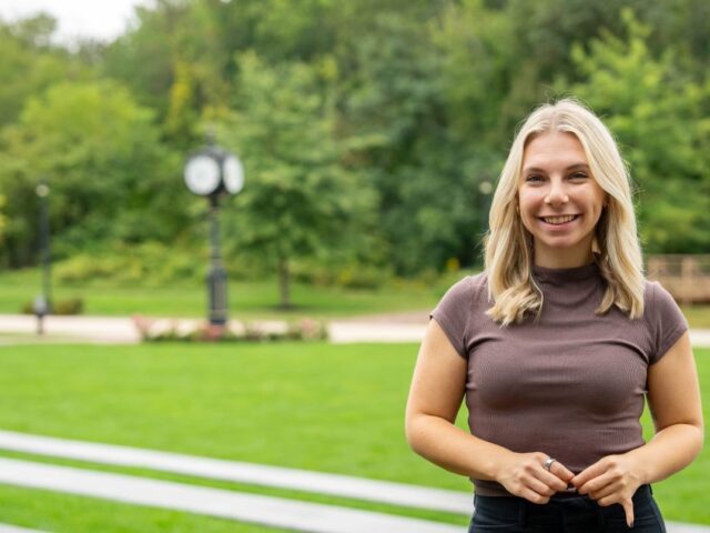 Online Ed.D. candidate at Rowan University smiling outside.