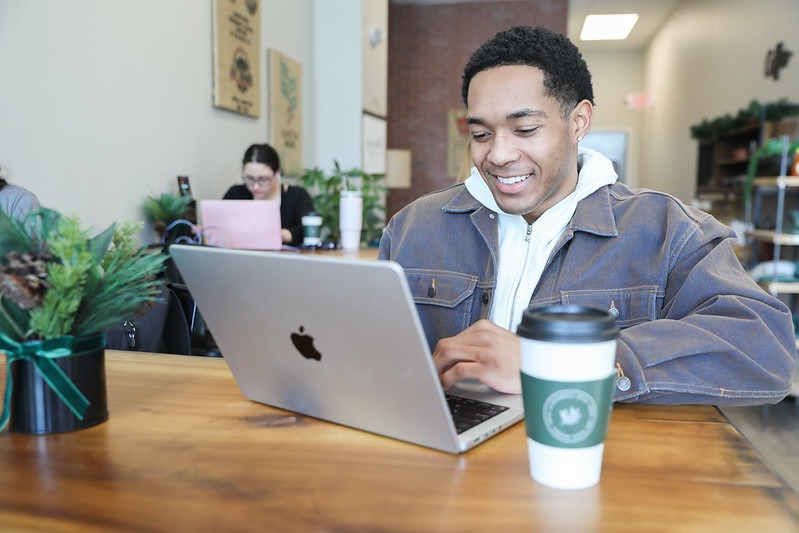 Online psychology completing coursework for his degree in a coffee shop.