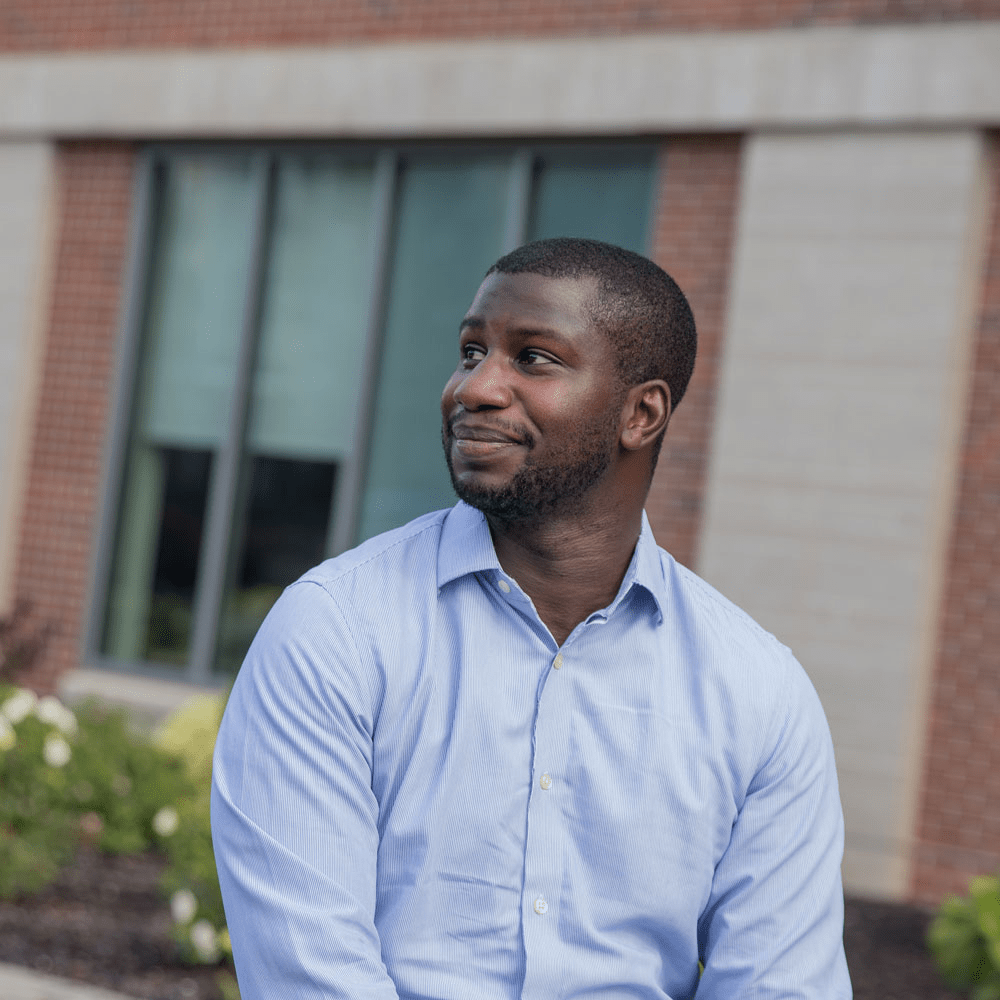 Rowan Online graduate student looking away smiling on Rowan University's campus.