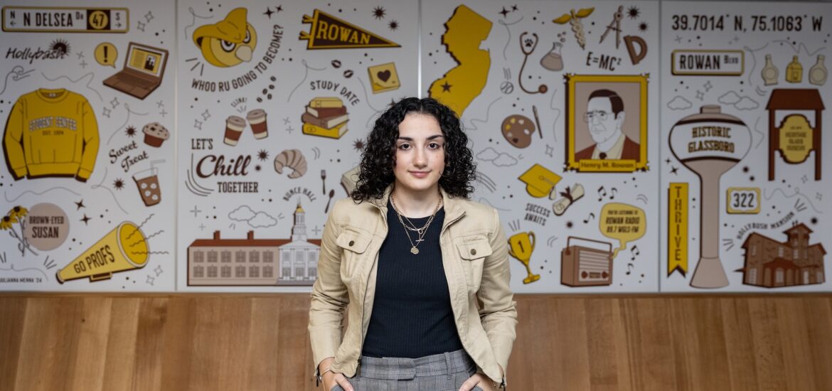 Julianna stands in front of her mural in Rowan's Student Center.